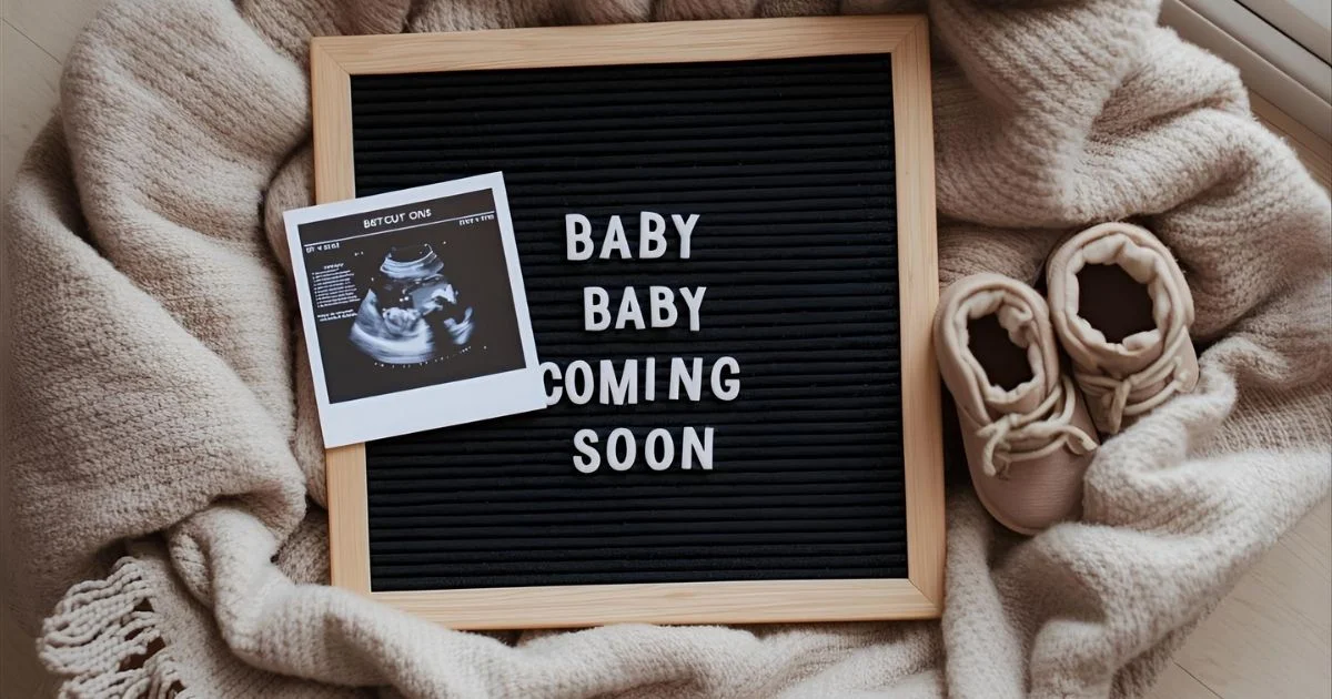flat-lay of baby onesie, tiny socks, ultrasound and letter board announcing a baby on the way on a soft neutral blanket
